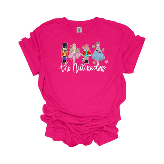 A fuchsia pink t-shirt with a graphic of Nutcracker ballet characters laid flat on a white background.