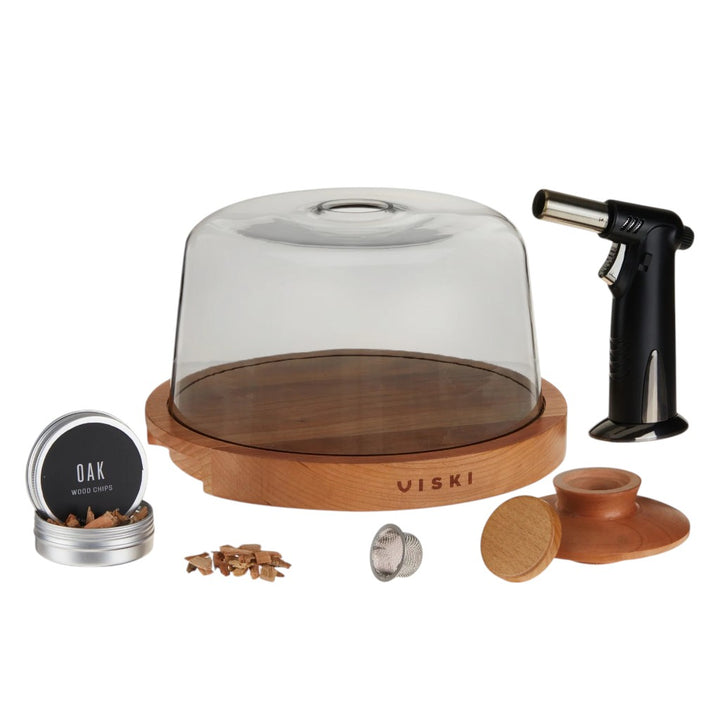  The complete 5-piece Viski Alchemi cocktail smoking set beautifully displayed on a white background, featuring the glass cloche, wooden base, torch, mesh strainer, and oak wood chips.