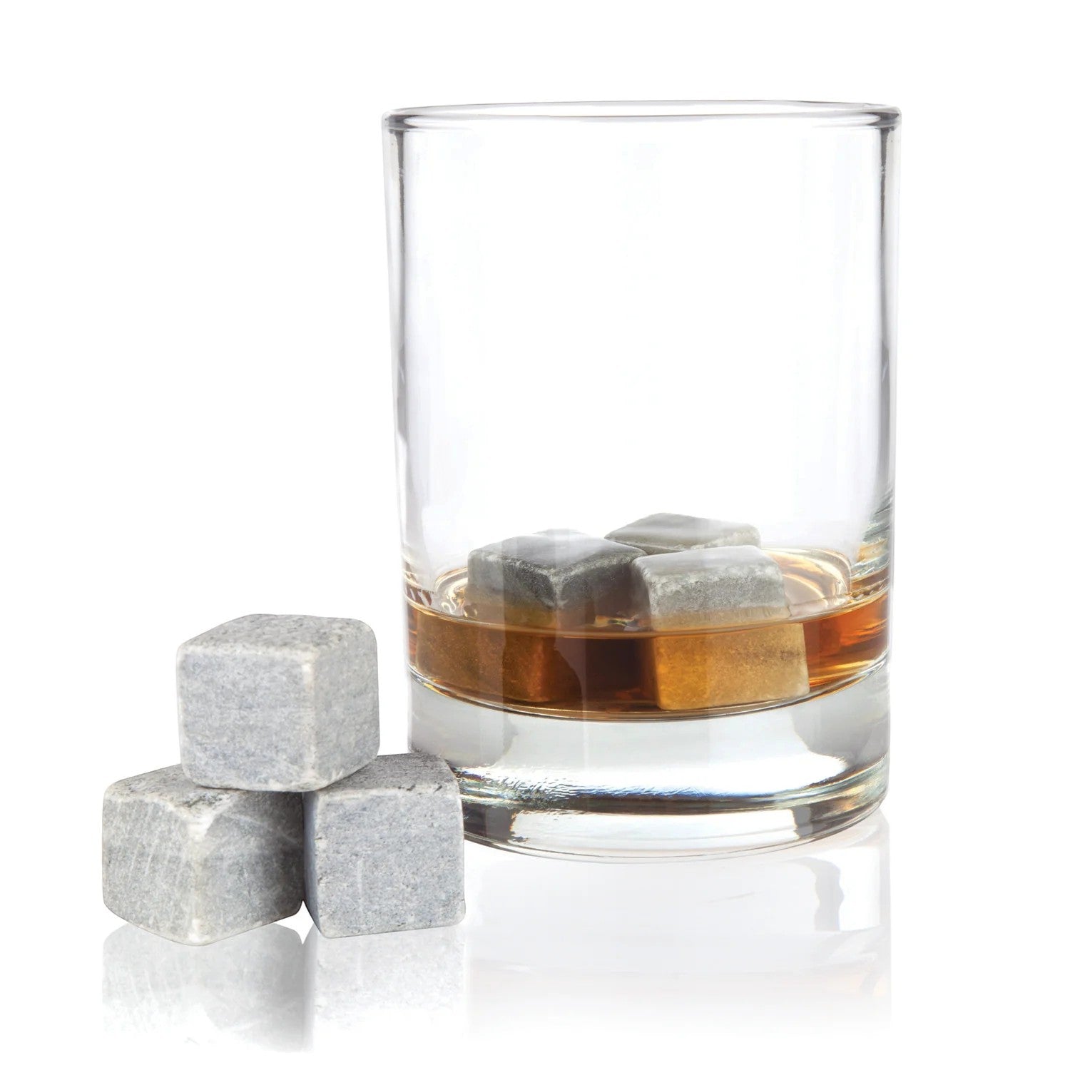 Glass of whiskey with ice cubes and three additional stones on a white background
