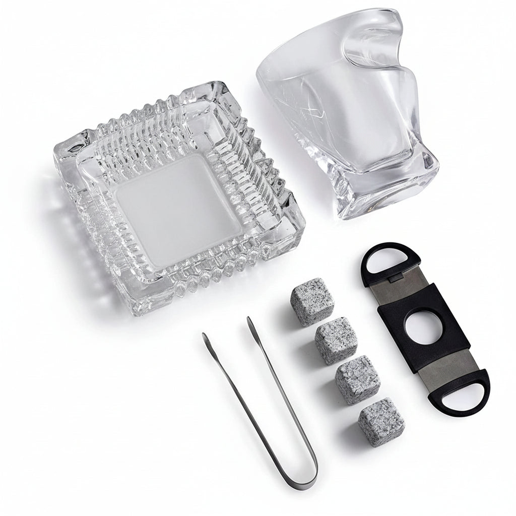 A close-up of the uniquely shaped 10 oz whiskey glass alongside the four granite chilling stones and tongs.
