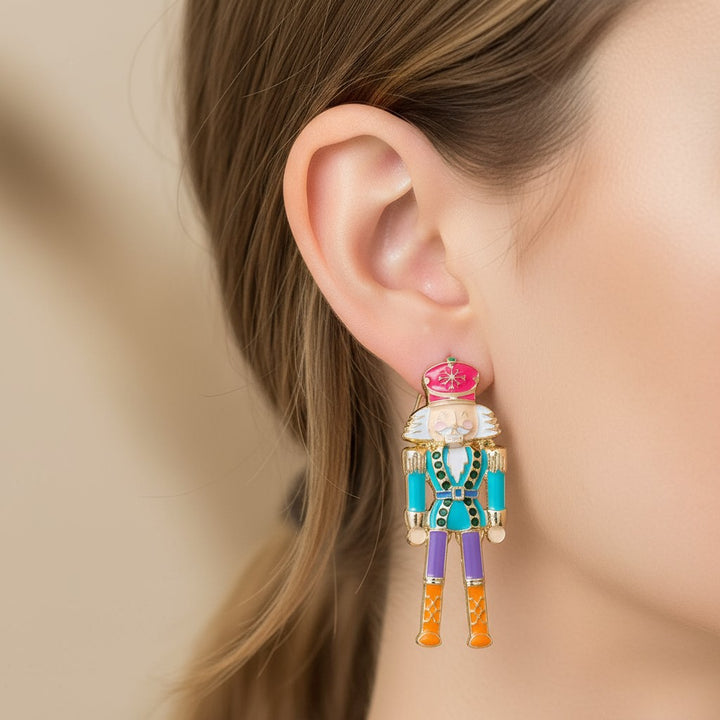 A lifestyle photo of a woman smiling while wearing the nutcracker statement earrings.