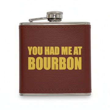 Brown leather flask with 'YOU HAD ME AT BOURBON' text on a white background
