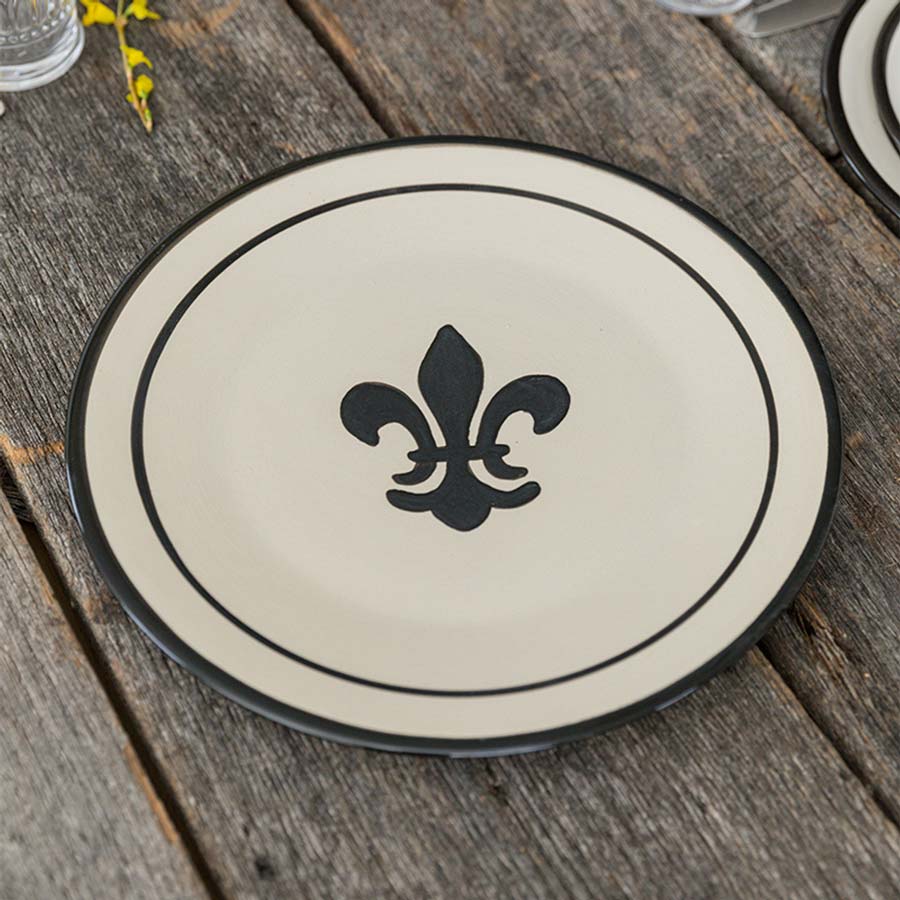 White Stoneware 14" Round Platter with Black hand-painted Fleur de Lis symbol on wooden table